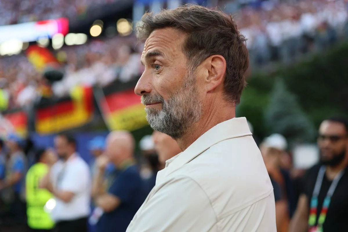 Jurgen Klopp is set to become the new Germany manager. Jurgen Klopp reacting to a football game in front of a German flag