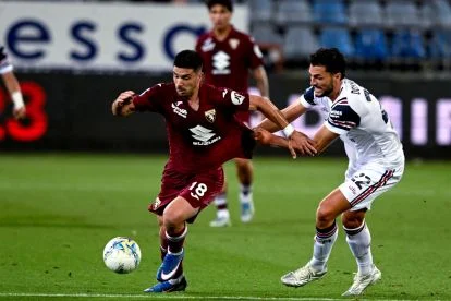CAGLIARI, ITALY - MAY 17: Giovanni Simeone of Torino in contrast with Alberto Dossena of Cagliari during the Serie A match between Cagliari Calcio and Torino FC at Stadio Sant'Elia on May 17, 2026 in Cagliari, Italy. (Photo by Enrico Locci/Getty Images)